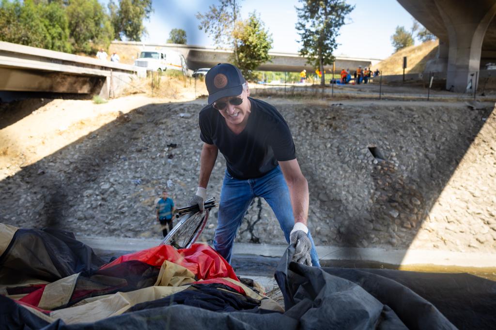 Governor Gavin Newsom cleans up an encampment site near Paxton Street and Remick Avenue in Los Angeles as the state's Clean California initiative continues on Thursday, Aug. 8, 2024 in Los Angeles, CA