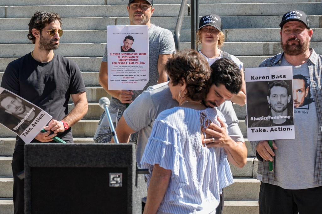 Micah Parker "Vampire Diaries," actor, producer, and organizer of Justice for Johnny Wactor, hugs Johnny's mother, Scarlett Wactor, during a news conference outside Los Angeles City Hall on Aug. 13, 2024.