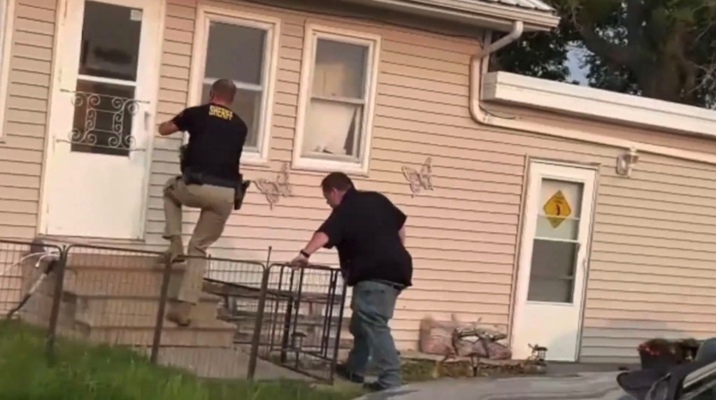 A photo of two cops racing into a house in South Dakota.