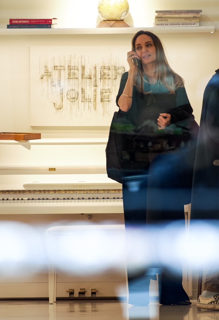 Angelina Jolie talking on a phone at Atelier Jolie, a high-end boutique and art space in a historic building in New York City