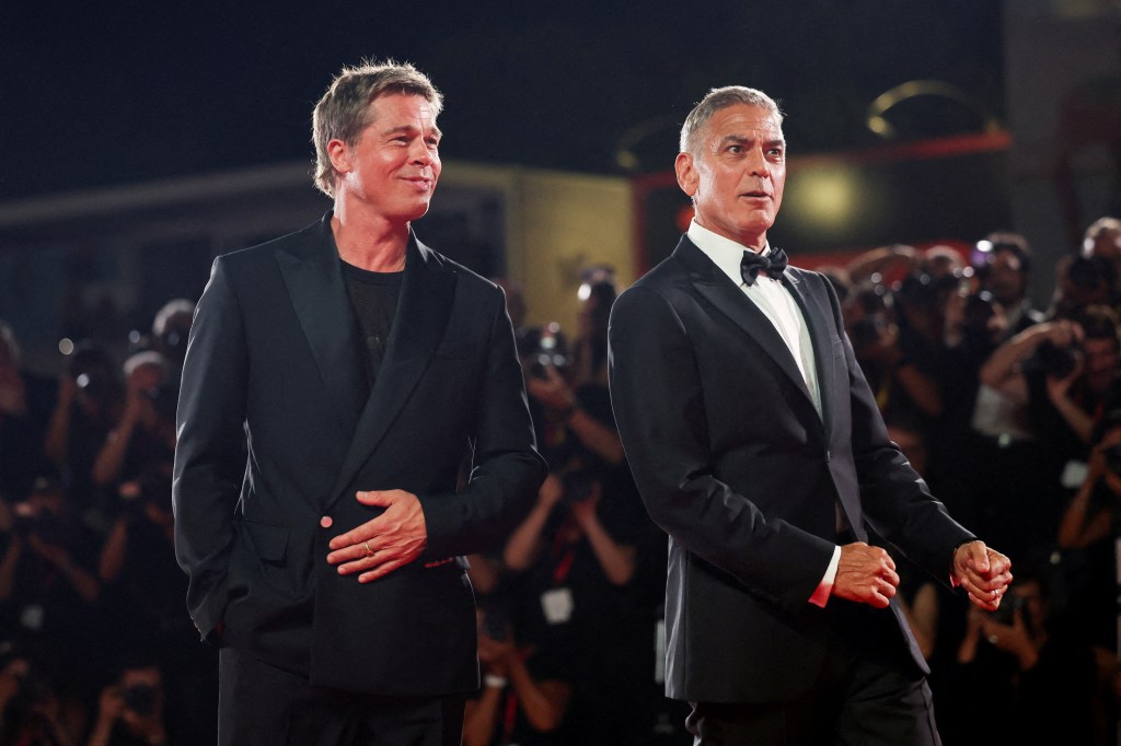 Brad Pitt and George Clooney posing on the red carpet at the 81st Venice Film Festival for the premiere of their movie, 'Wolfs'.