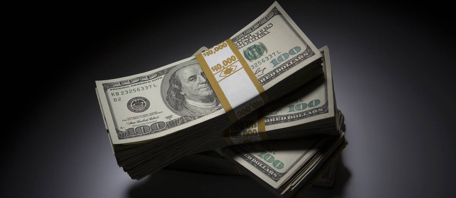 Pacotes com notas de US$ 100. Foto: Scott Eells / Bloomberg