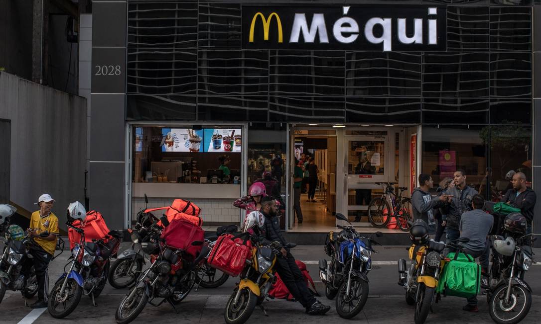 Entregadores na frente de uma loja do McDonald's, em São Paulo Foto: Victor Moriyama / Bloomberg