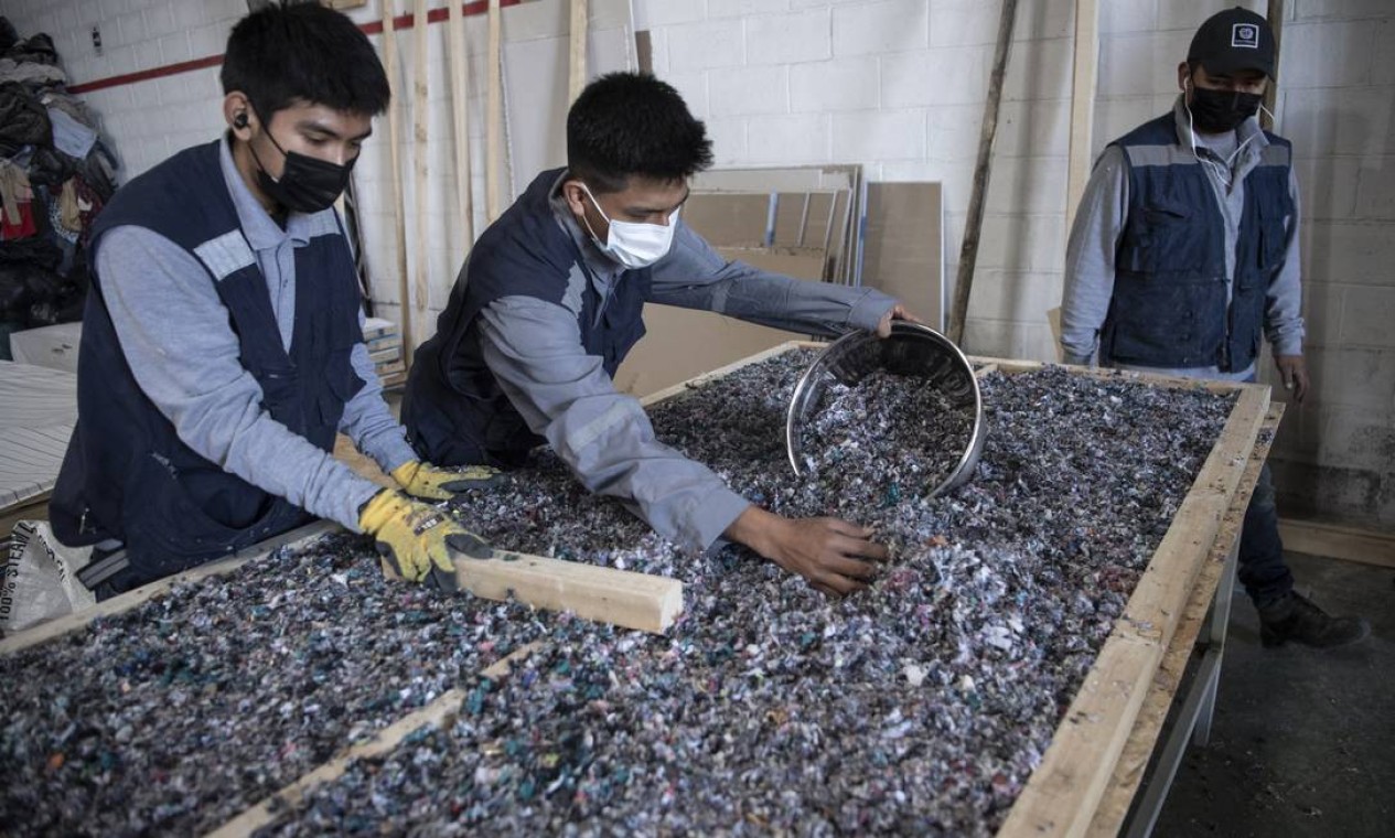 Trabalhadores de uma fábrica que recicla roupas descartadas no deserto do Atacama Foto: MARTIN BERNETTI / AFP