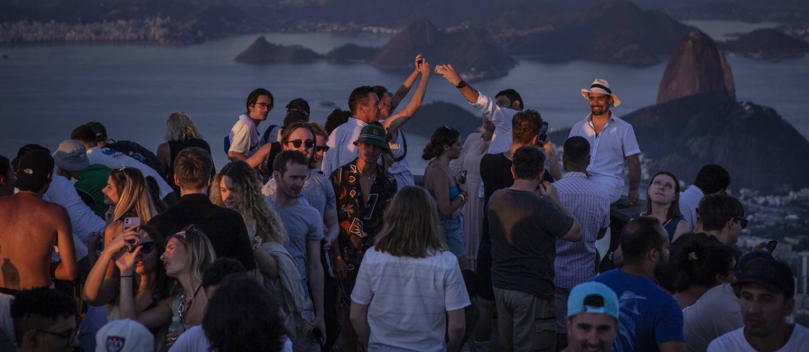 Turistas fotografam o Cristo Redentor: queda no número de casos de Covid-19 e reabertura de fronteiras globalmente contribuíram para a retomada do setor de turismo Foto: Alexandre Cassiano / Agência O Globo