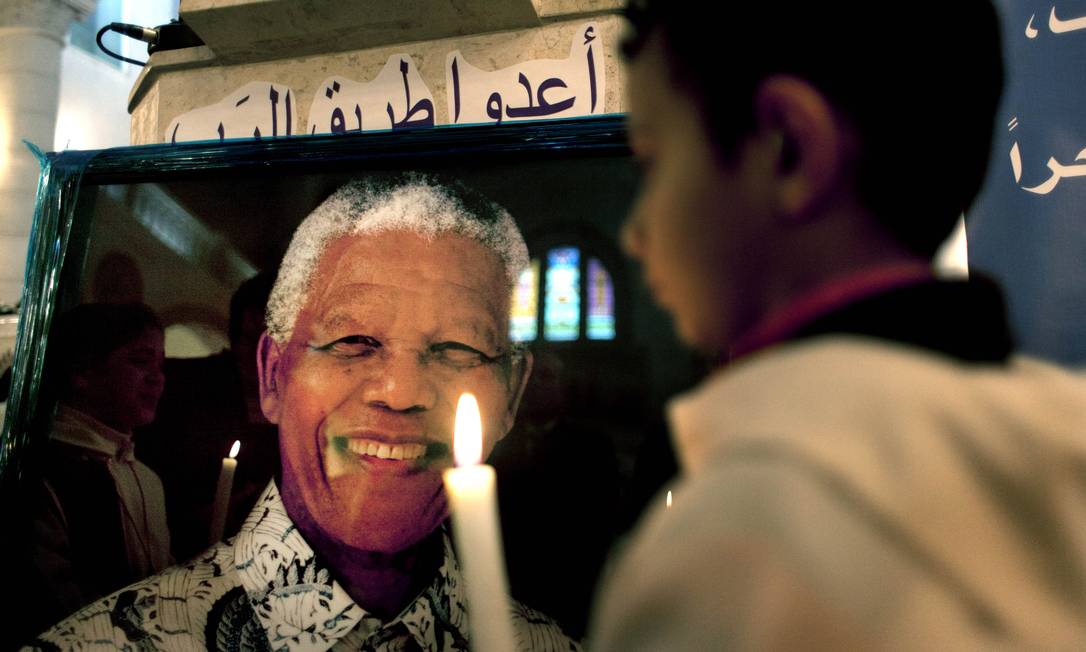 
Criança palestina ilumina foto de Mandela em Ramallah, Cisjordânia, durante culto dedicado ao líder
Foto: Nasser Nasser / AP