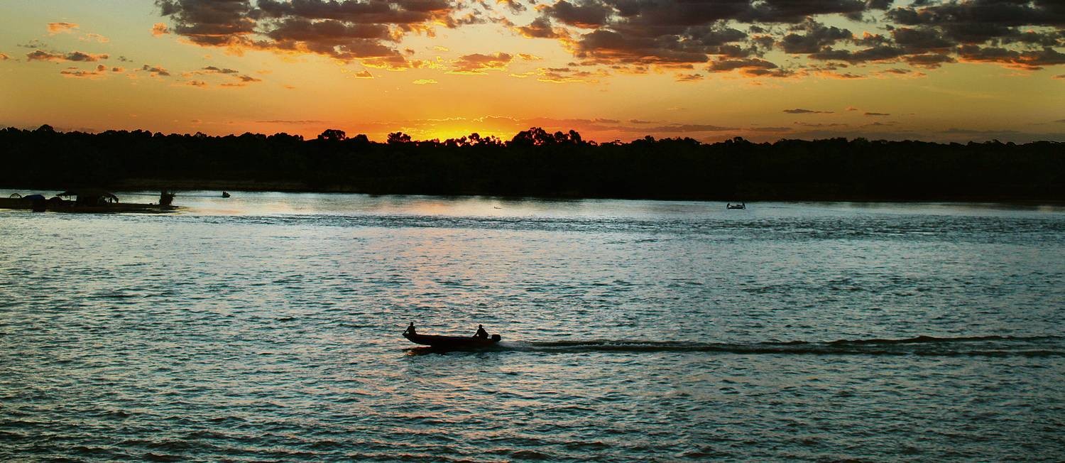 Bote a motor descendo o rio ao pôr do sol, numa imagem típica do Araguaia Foto: Eduardo Vessoni / Especial para O GLOBO