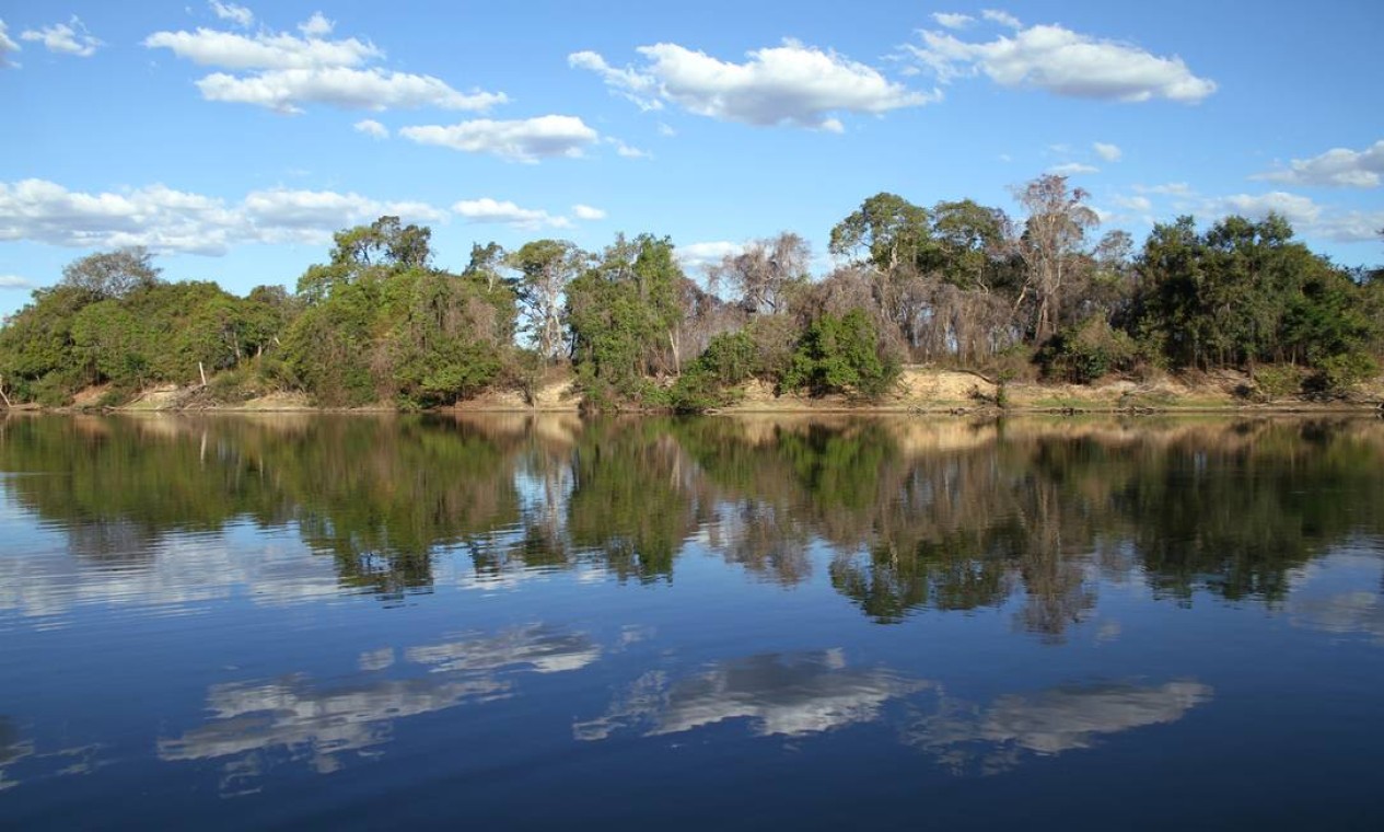 Ao longo de seus 2.000km pelo oeste de Goiás, o Rio Araguaia tem inúmeras faces. Em pontos como este, as águas calmas refletem as árvores e o céu como num espelho Foto: Eduardo Vessoni