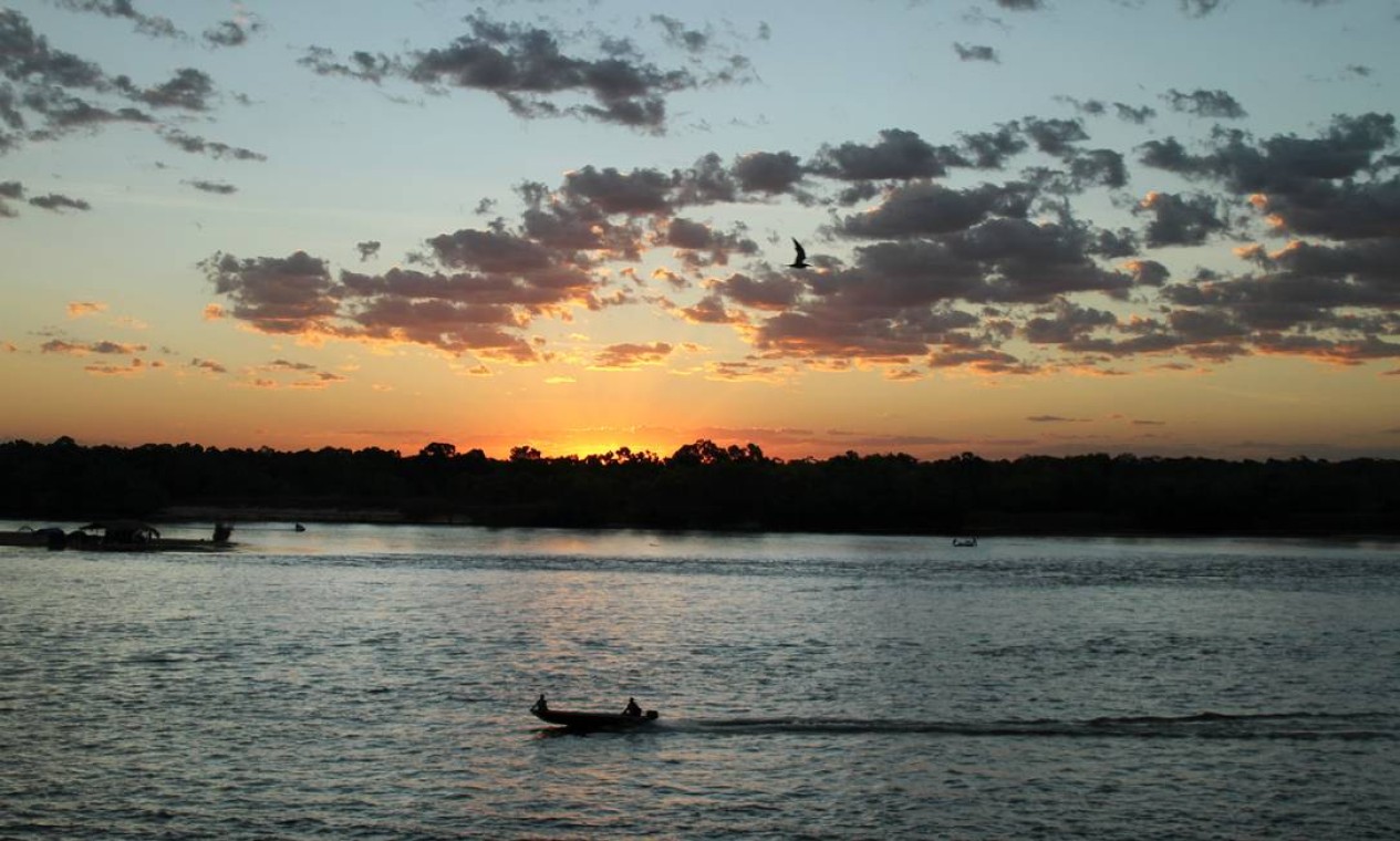 Um barco a motor desce o rio ao pôr do sol, num dos cenários mais reconhecíveis desse Araguaia mutante Foto: Eduardo Vessoni