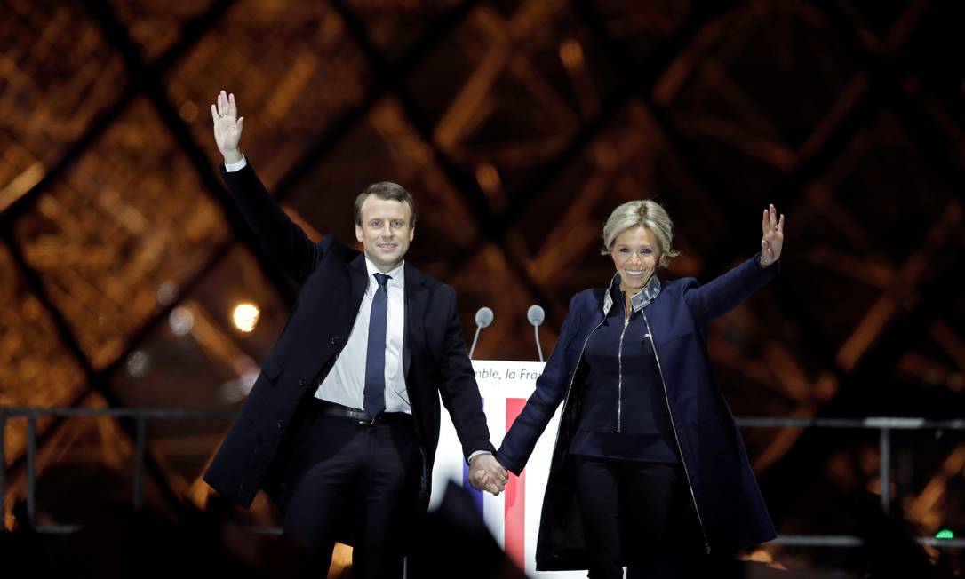 O presidente eleito da França, Emmanuel Macron, e sua mulher, Brigitte Trogneux, celebram a vitória na esplanada do Louvre em Paris Foto: BENOIT TESSIER / REUTERS