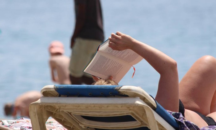 No verão, tape o sol na cara com um livro e aproveite para pôr a leitura em dia Foto: Pixabay