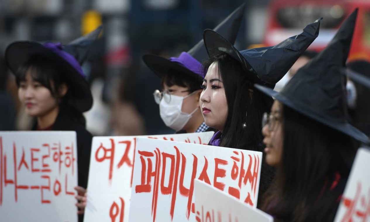 Mulheres vestidas de bruxas seguram cartazes com dizeres feministas em Seul, na Coreia do Sul para marcar o Dia Internacional da Mulher 2019 Foto: JUNG YEON-JE / AFP