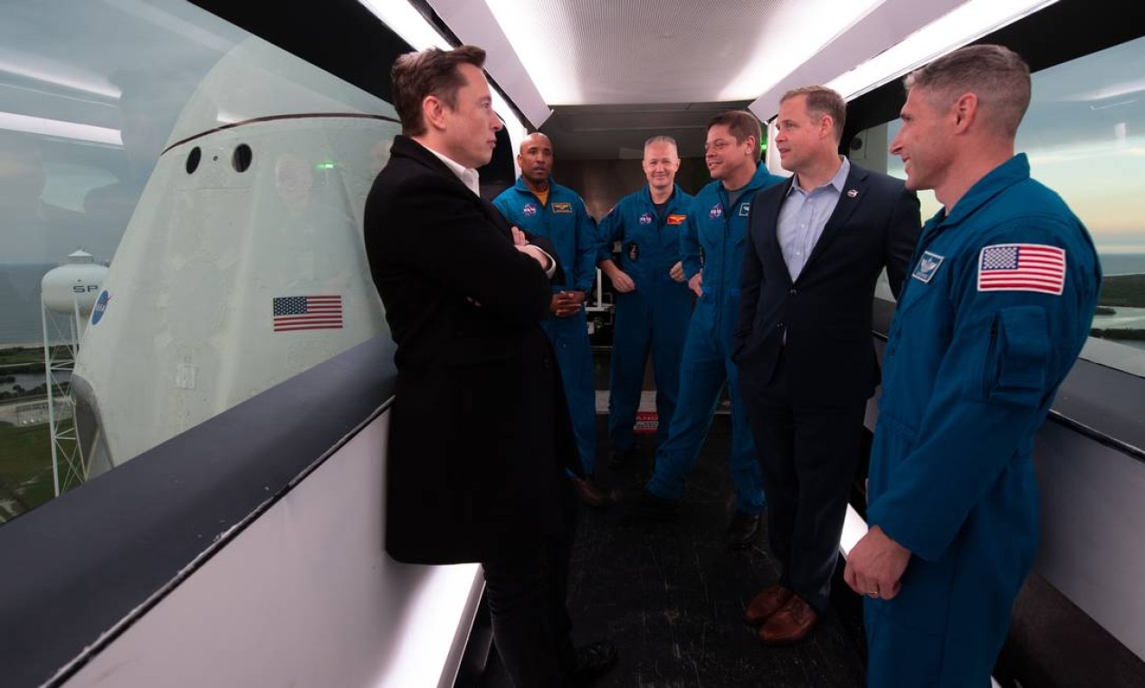 Musk junto dos astronautas da NASA Victor Glover, Doug Hurley, Bob Behnken, o administrador da NASA, Jim Bridenstine, e o astronauta da NASA Mike Hopkins, dentro do braço de acesso da tripulação Foto: JOEL KOWSKY / AFP