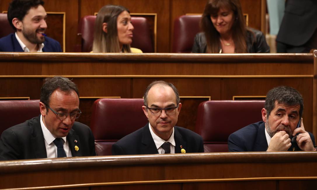 
Foto da última terça, 21 de maio, mostra os recém-eleitos deputados catalães Jordi Sanchez, Jordi Turull e Josep Rull (da direita para a esquerda, da fila frontal) durante a sessão de abertura da nova Legislatura: mandatos dos três, mais o do colega Oriol Junqueras, foram suspensos nesta sexta
Foto:
SERGIO PEREZ/AFP/21-05-2019
