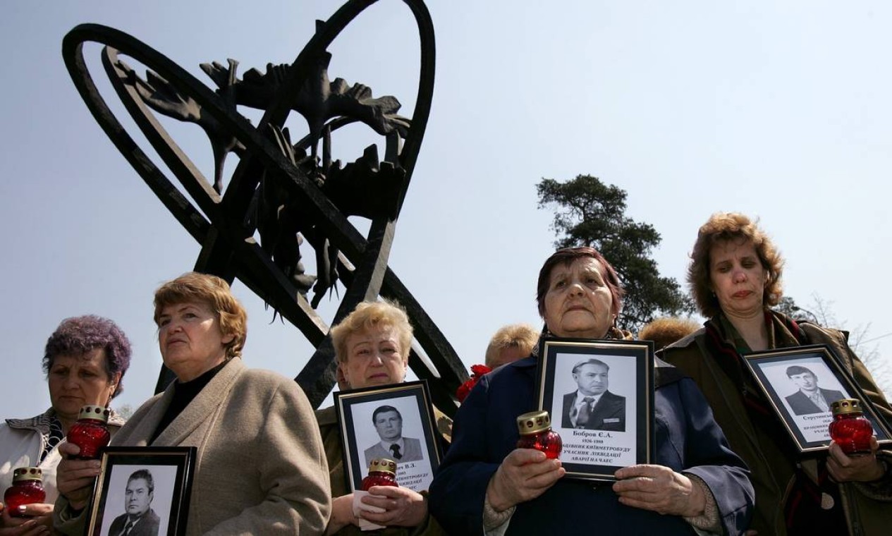 Viúvas de mortos em Chernobyl seguram fotos de seus maridos diante de um monumento em homenagem às vítimas da usina em Kiev, na Ucrânia, em abril de 2006 Foto: Denis Sinyakov / AFP PHOTO