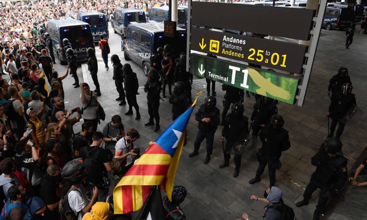 Policiais fazem uma barreira do lado de fora do aeroporto para impedir a entrada de manifestantes Foto: JOSEP LAGO / AFP