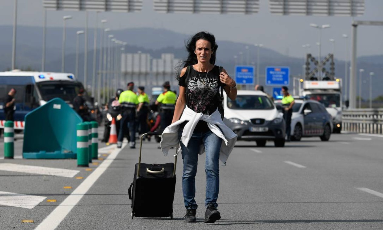 Em razão do protesto, acessos ao Aeroporto El Prat fiicaram congestionados, obrigando quem tinha viagem marcada a caminhar até o o terminal aeroviário Foto: LLUIS GENE / AFP