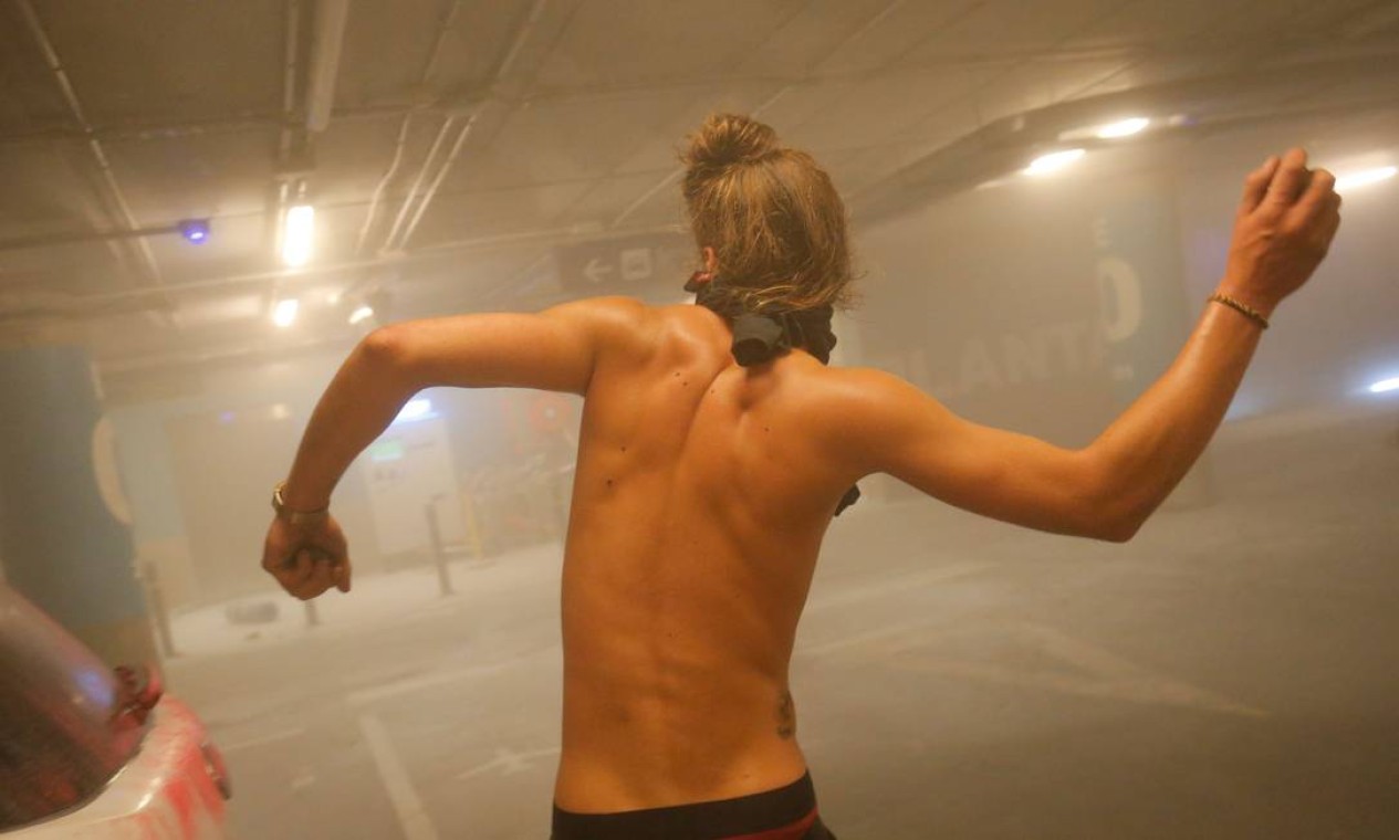 Um manifestante atira pedras durante os confrontos com policiais espanhóis no Aeroporto de El Prat, em Barcelona Foto: PAU BARRENA / AFP