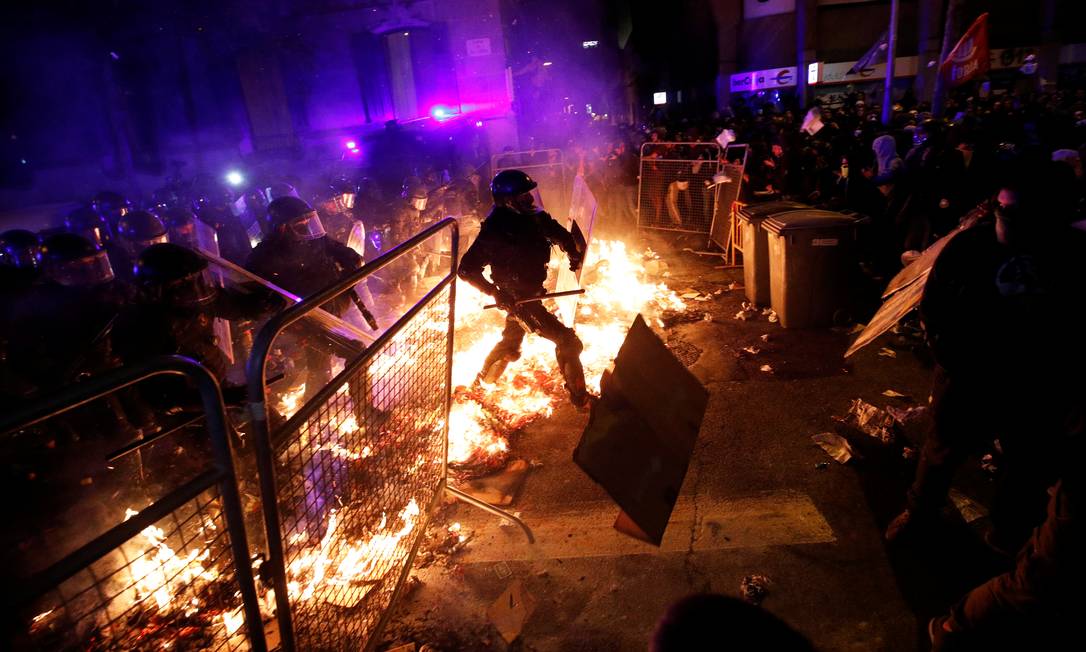 Polícia avança contra barricada montada por manifestantes em uma rua de Barcelona. Protestos bloquearam estradas e o principal aeroporto da região Foto: ALBERT GEA / REUTERS