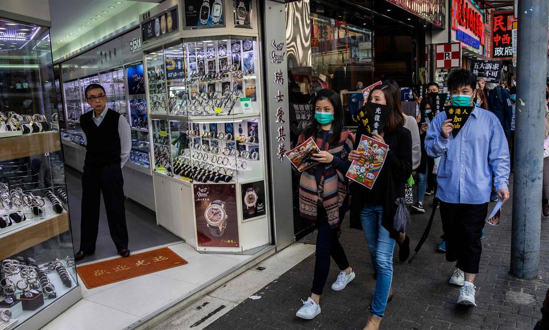 Preocupados com a epidemia, os moradores de Hong Kong correram para comprar máscaras respiratórias, vendidas em farmácias. Foto: ISAAC LAWRENCE / AFP