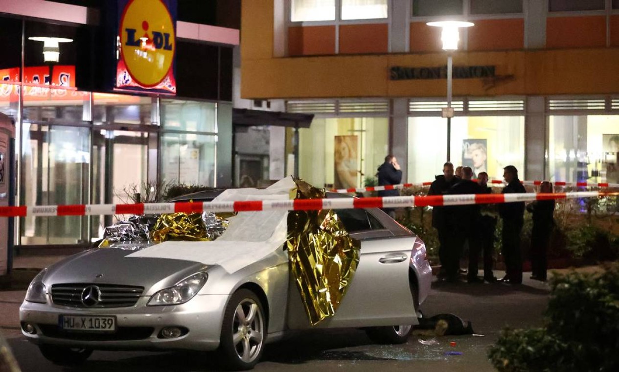 Uma das vítimas é vista perto de um carro danificado no local onde assassinos abriram fogo nesta quarta-feira. Tiros foram disparados contra pessoas que estavam em dois bares onde se fuma narguilé, espécie de cachimbo de água muito comum no Oriente Médio Foto: KAI PFAFFENBACH / REUTERS