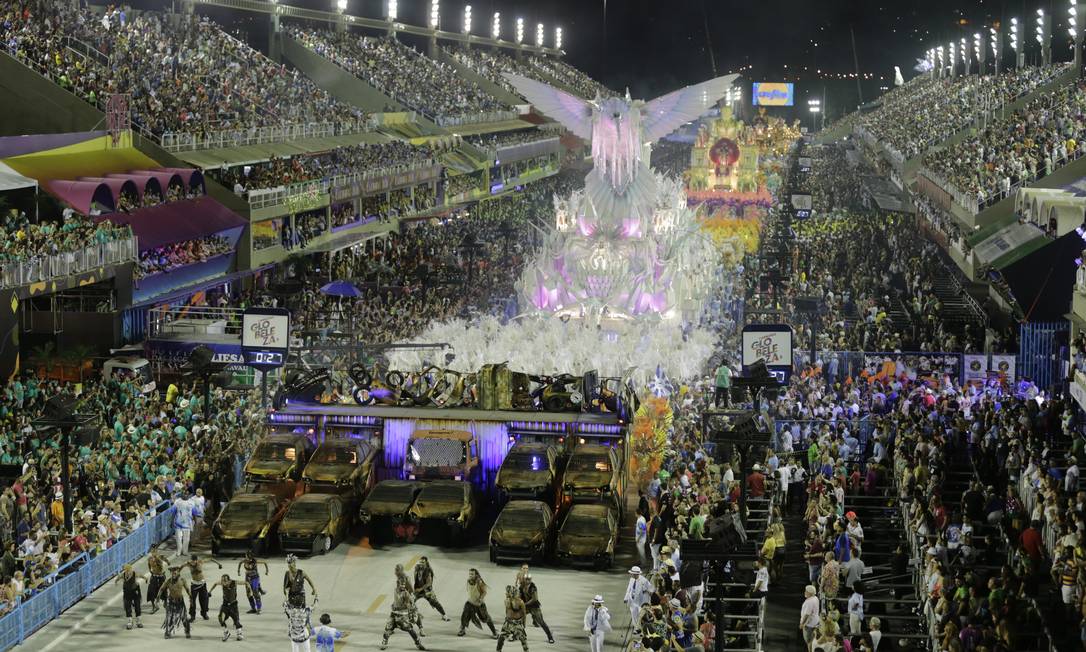 Bailarinos da Comissão de Frente da Beija-flor, no estilo Mad Max: carcaças de carro compõem ala. Ao fundo, abre-alas com a ave símbolo da escola Foto: Alexandre Cassiano / Agência O GLOBO