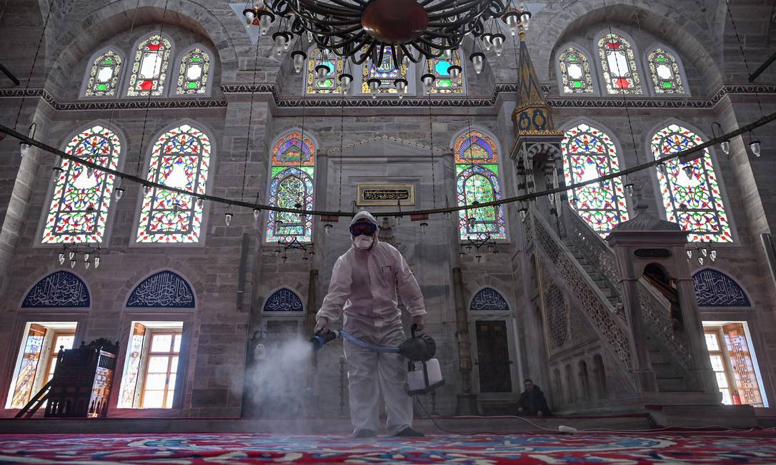 Funcionário da prefeitura de Istambul, na Turquia, desinfeta a mesquita Mihrimah Sultan como medida para evitar a expansão da Covid-19: país também está em alerta Foto: OZAN KOSE / AFP