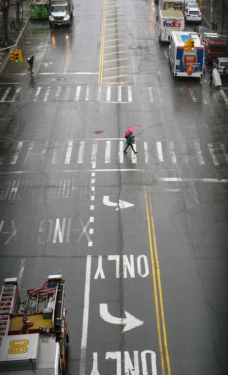 Dois pedestres atravessam a West 125th Street, no bairro do Harlem, em Nova York Foto: CHANG W. LEE / Agência O Globo