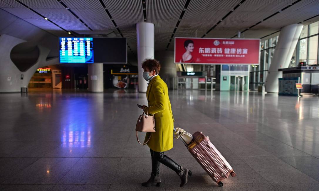 Mulher é vista em estação de trem em Wuhan, após reabertura no sistema ferroviário Foto: HECTOR RETAMAL / AFP