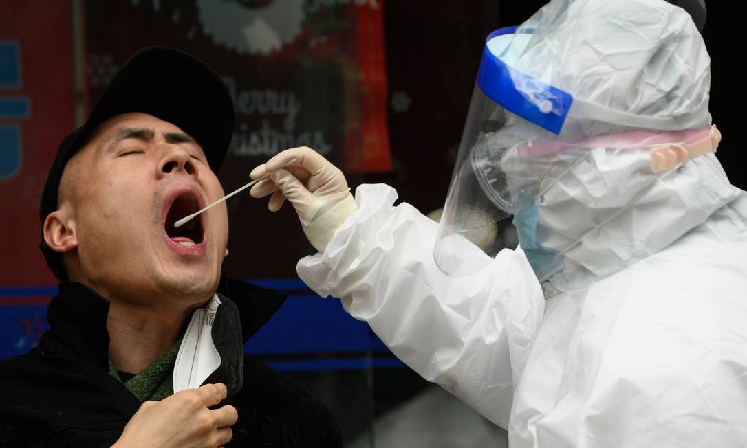 Médico testa paciente para coronavírus em uma clínica de Wuhan, na China Foto: NOEL CELIS / AFP/28-03-2020