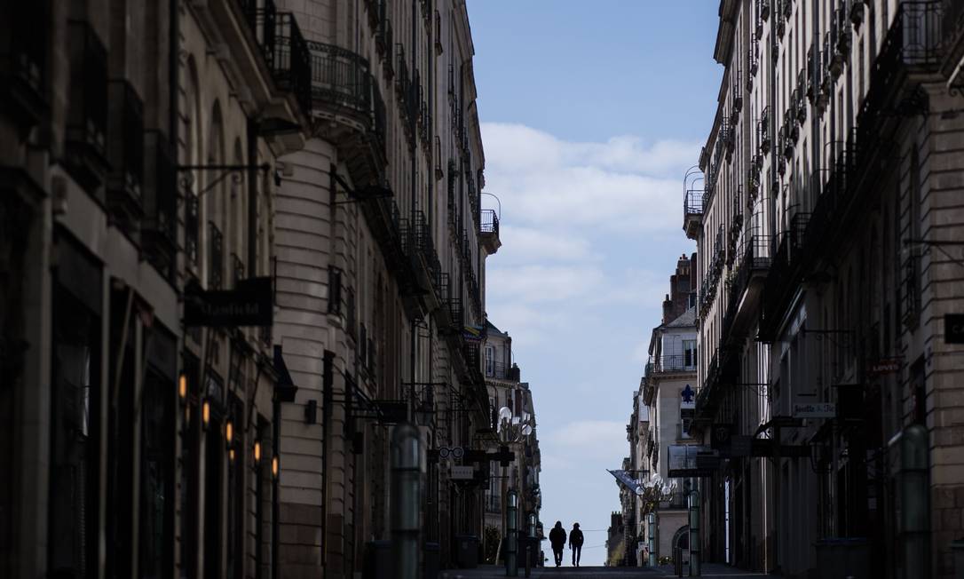 Casal desce uma rua em Nantes, no Oeste da França, no 13º dia de confinamento devido à Covid-19 Foto: LOIC VENANCE / AFP/29-03-2020