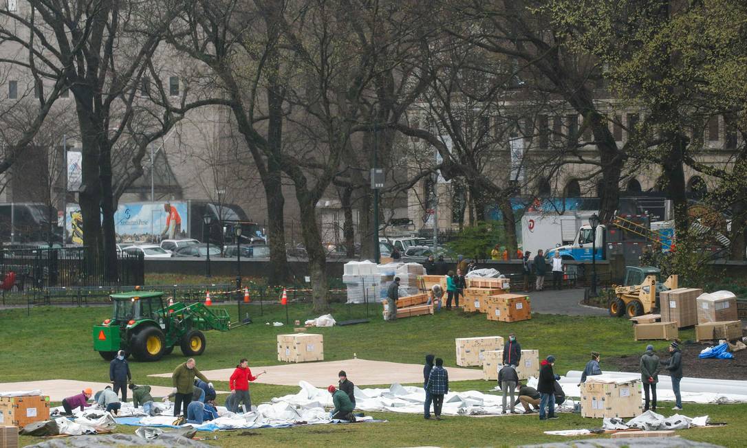 Trabalhadores montam um hospital de campanha no Central Park, em Nova York, cidade mais atingida pelo coronavírus nos EUA Foto: KENA BETANCUR / AFP