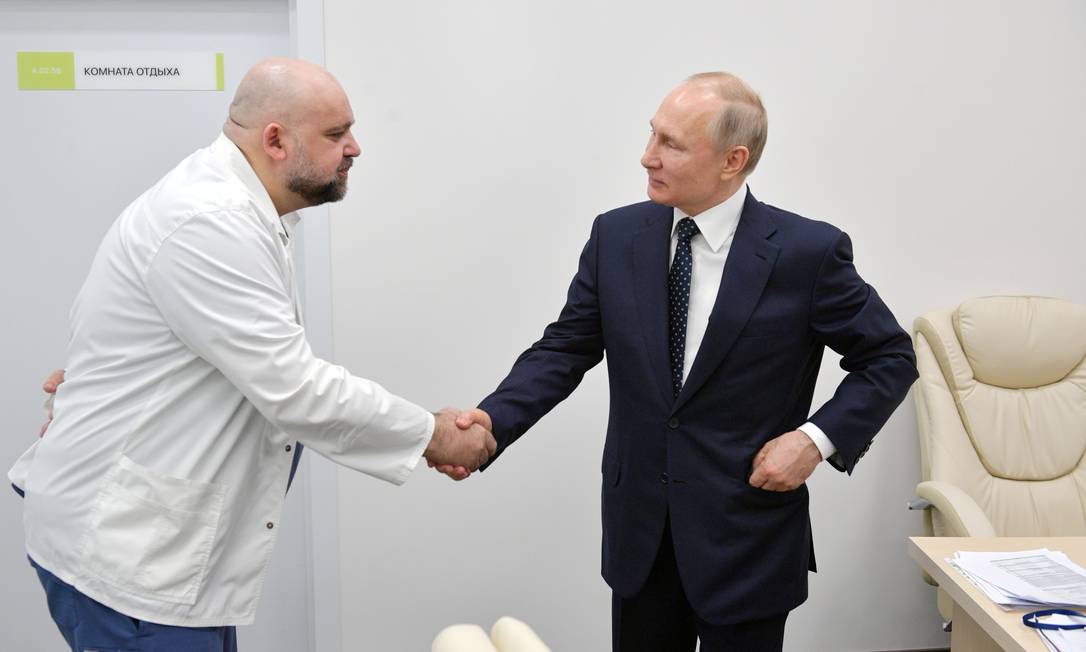 O presidente russo, Vladimir Putin, aperta a mão do médico Denis Protsenko durante visita a um hospital de pacientes de coronavírus Foto: SPUTNIK / via REUTERS/24-03-2020