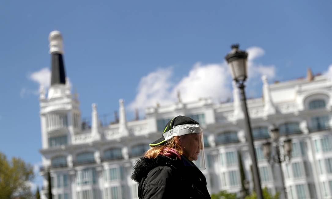 Mulher usando máscara de proteção caseira caminha nas ruas de Madri, na Espanha Foto: SUSANA VERA / REUTERS/04-04-2020