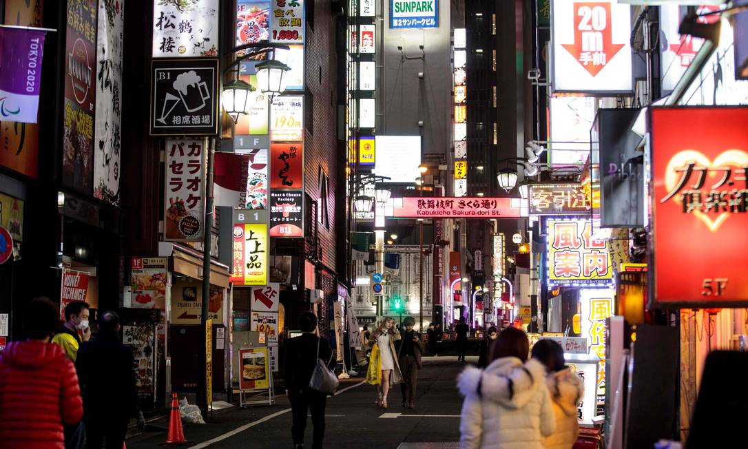 Pessoas caminham no distrito de Kabukicho, em Tóquio
Foto: BEHROUZ MEHRI / AFP