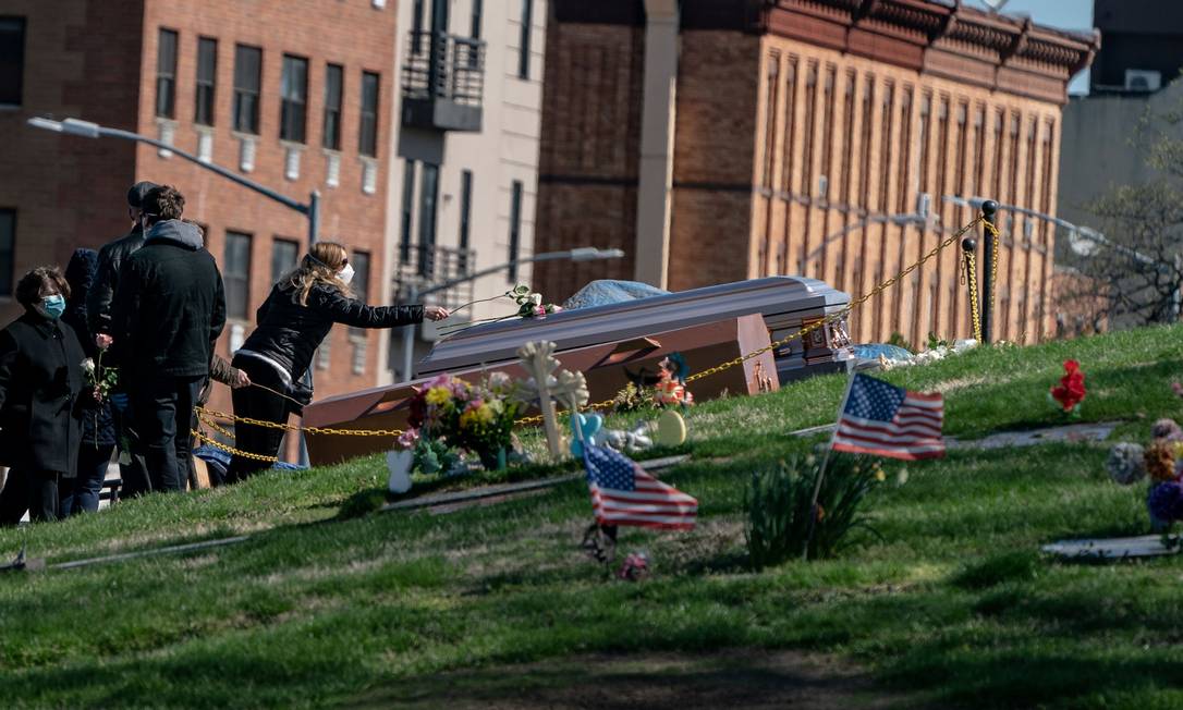 Com máscaras, americanos participam de funeral em cemitério no Brooklyn, em Nova York, durante o surto do coronavírus Foto: JEENAH MOON / REUTERS