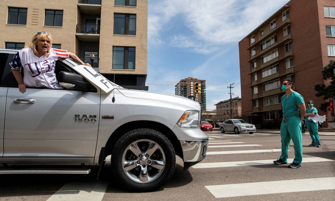 Contramanifestação: profissional da saúde bloqueia manifestante contrário ao isolamento social em Denver Foto: ALYSON MCCLARAN / REUTERS