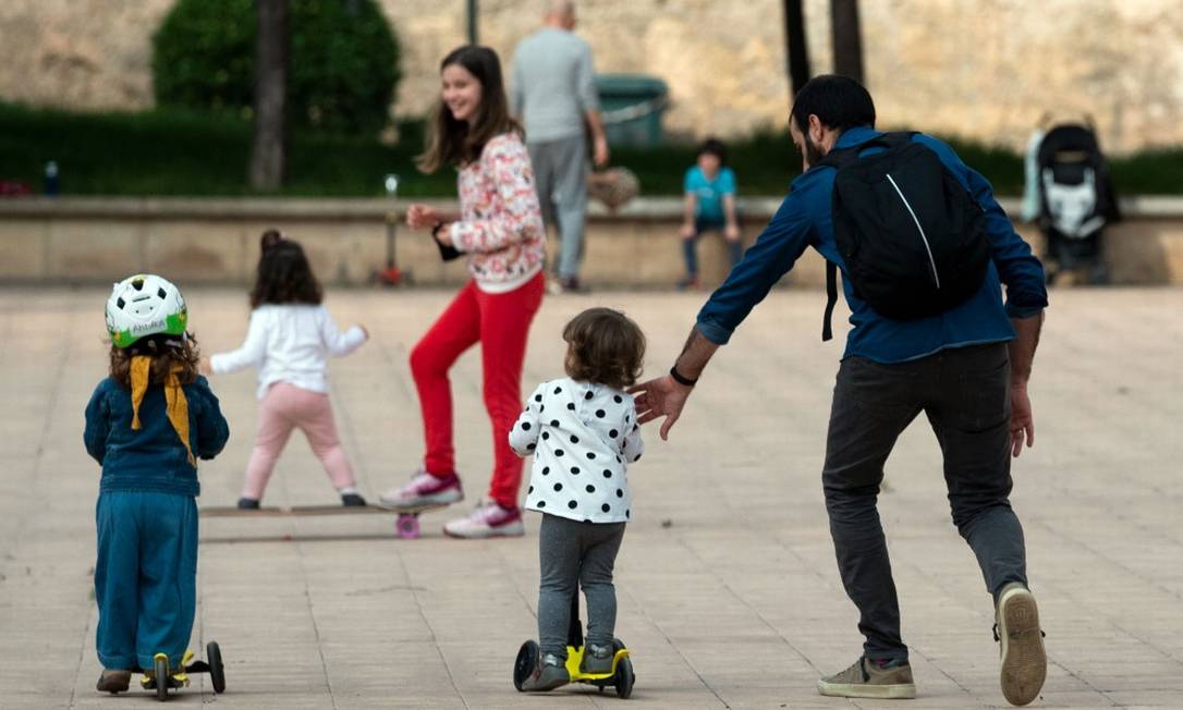 Crianças brincam ao ar livre em Valencia, na Espanha Foto: JOSE JORDAN / AFP