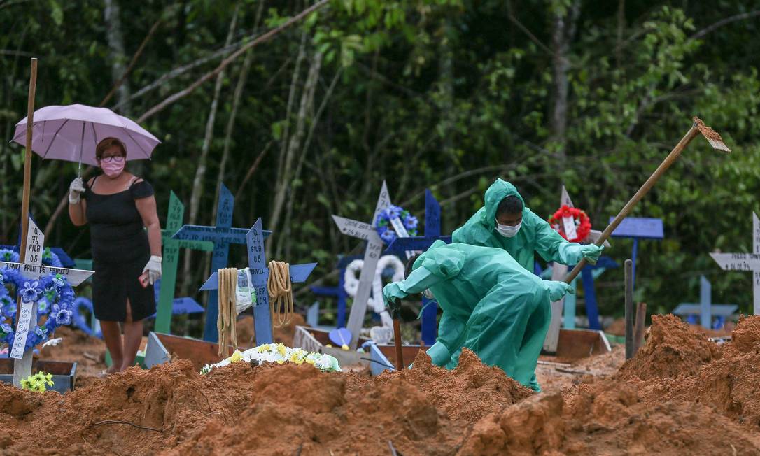 Coveiros trabalham para enterrar vítimas confirmadas e suspeitas do novo coronavírus, em Manaus Foto: MICHAEL DANTAS / AFP