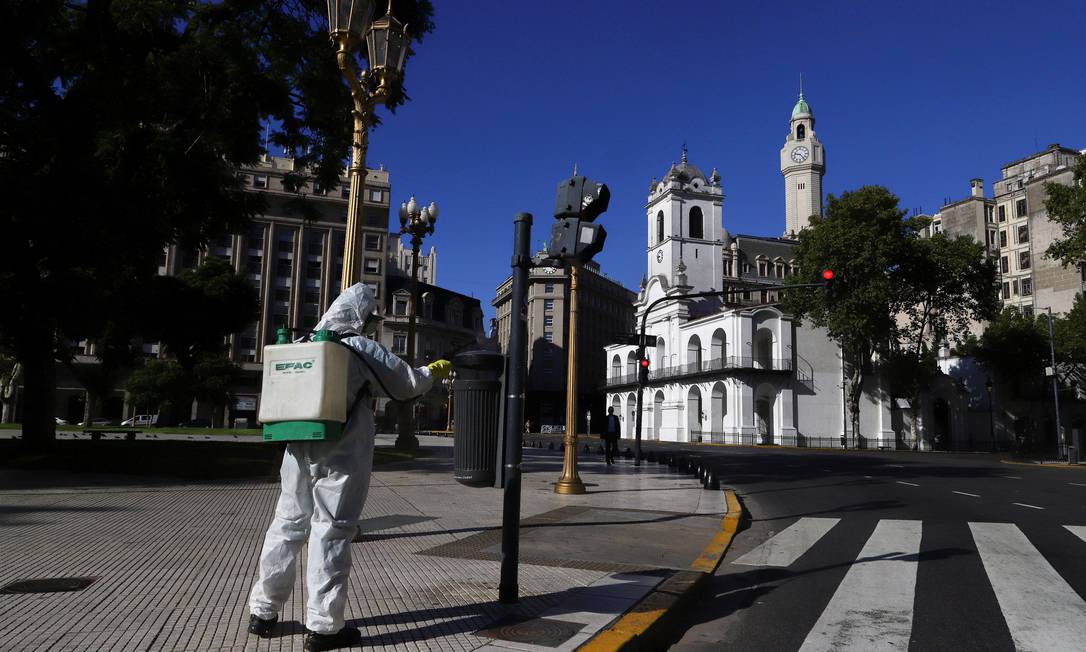 Homem desinfeta áreas da Praça de Maio, em Buenos Aires, como parte de ações para conter o avanço da Covid-19 no país Foto: Matias Baglietto / REUTERS