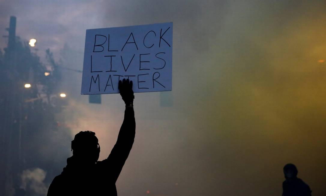 Em Minneapolis, manifestante segura cartaz que diz Black Lives Matter (Vidas Negras Importam) Foto: LINDSEY WASSON / REUTERS