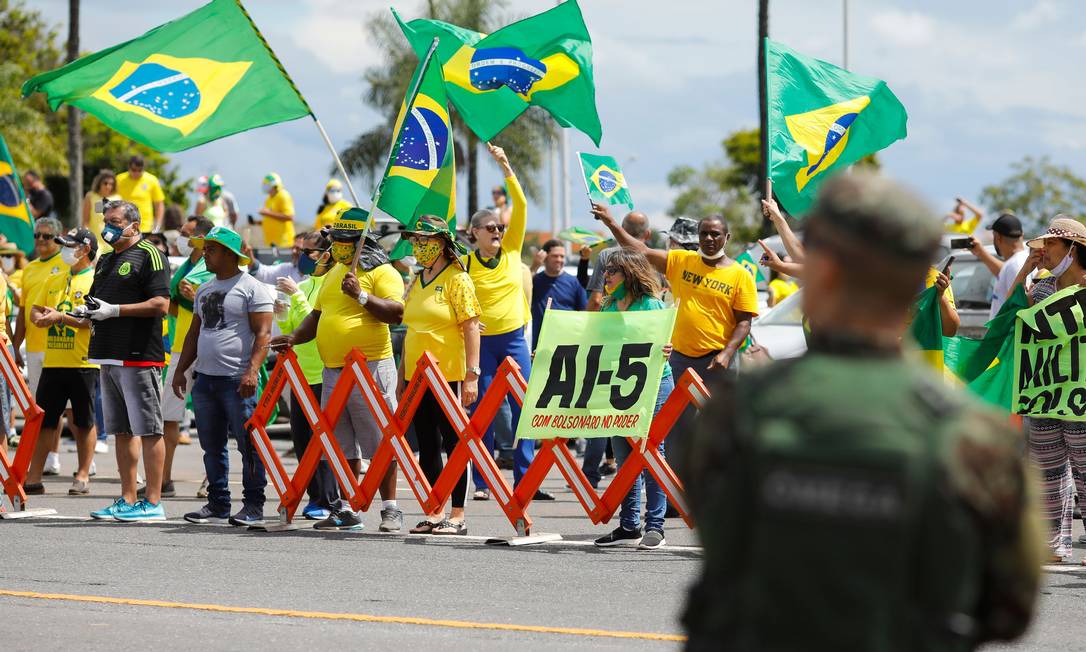 Apoiadores do presidente Jair Bolsonaro exibem cartaz com alusão ao AI-5 no Dia do Exército, em Brasília Foto: SERGIO LIMA / AFP