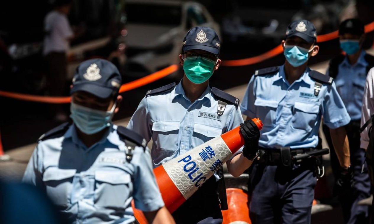 A polícia montou um cordão diante de Tong Ying-kit, na chegada ao tribunal de West Kowloon, em Hong Kong em 6 de julho de 2020 Foto: ISAAC LAWRENCE / AFP