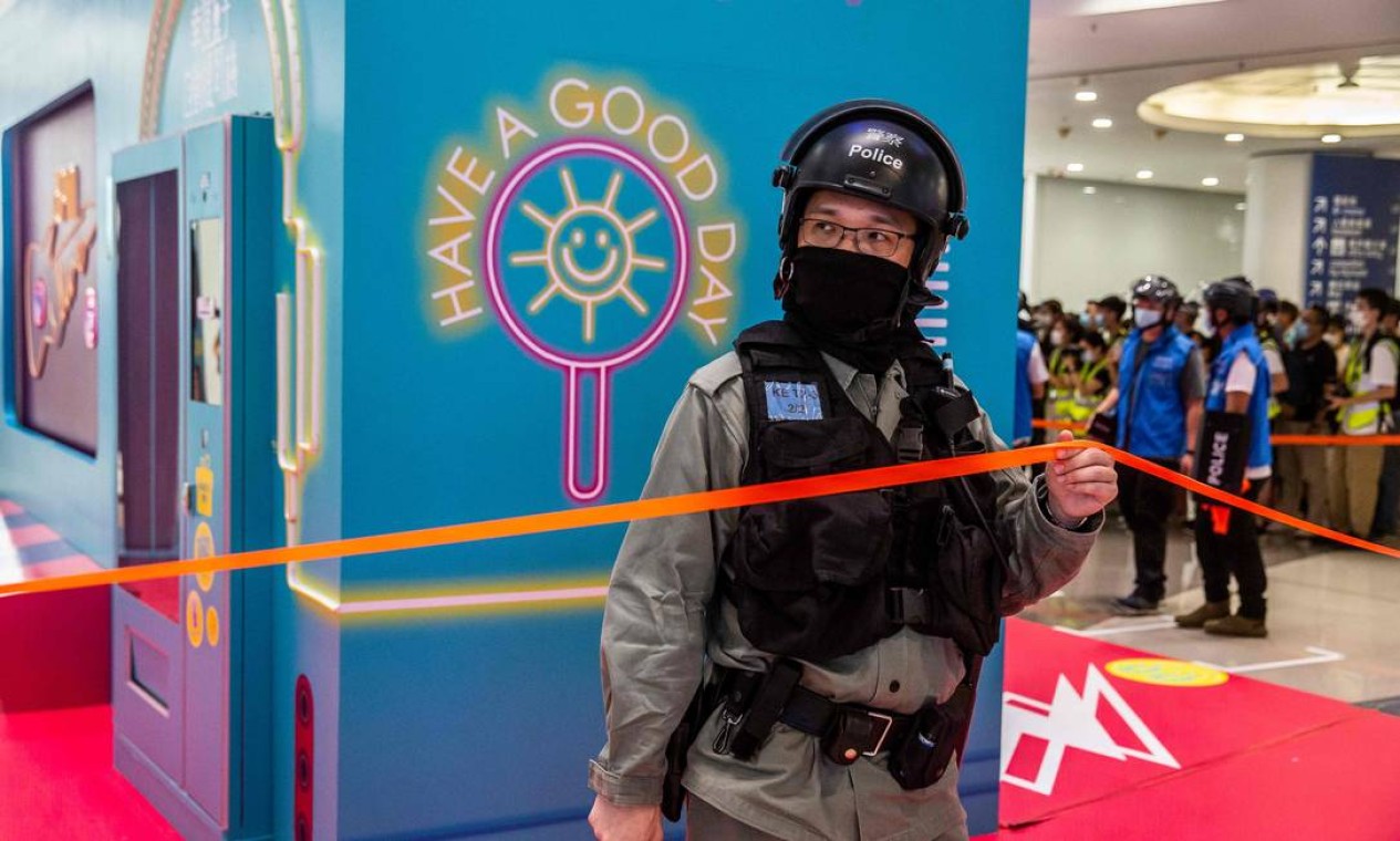 Um policial de choque fica de guarda durante uma operação de liberação durante uma manifestação, em um shopping em Hong Kong Foto: ISAAC LAWRENCE / AFP