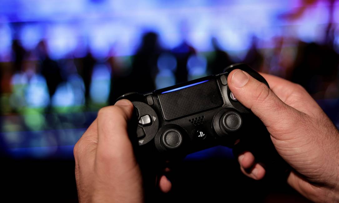 Um jogador usa controle de PS4 Foto: KENZO TRIBOUILLARD / AFP