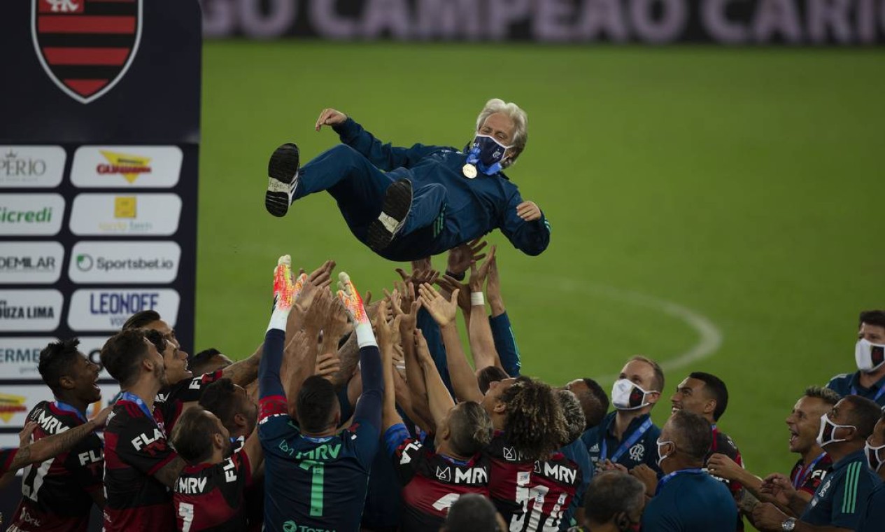 Técnico Jorge Jesus é erguido pelos jogadores do Flamengo após conquista de mais um título. Equipe rubro-negra bateu o Fluminense e ergueu a taça de de campeão Carioca num campeonato marcado pela disparidade e disputado
com em meio à pandemia e sem público na final Foto: Alexandre Cassiano / Agência O Globo - 15/07/2020