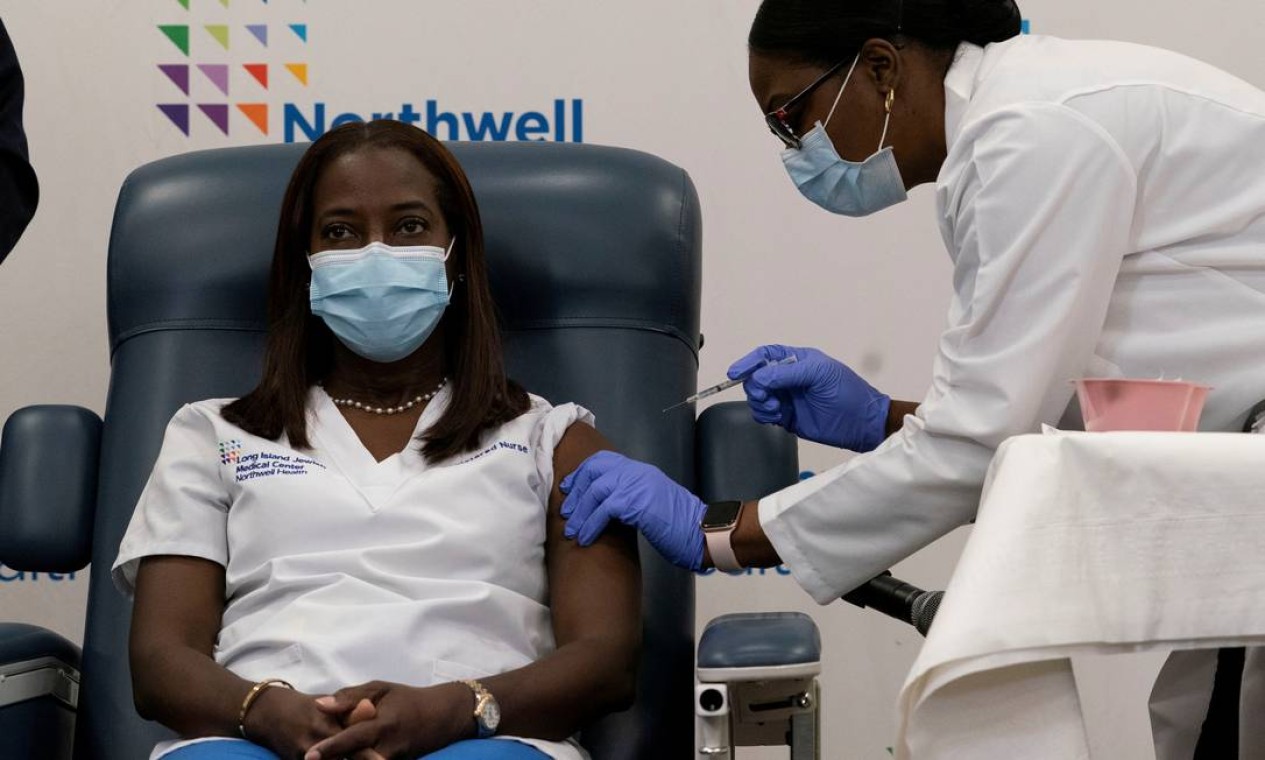 A enfermeira Sandra Lindsay, que atua na linha de frente contra a Covid-19 em uma Unidade de Terapia Intensiva, recebe a primeira dose da vacina contra Covid-19 no estado americano de Nova York. A aplicação foi transmitida ao vivo Foto: POOL / REUTERS