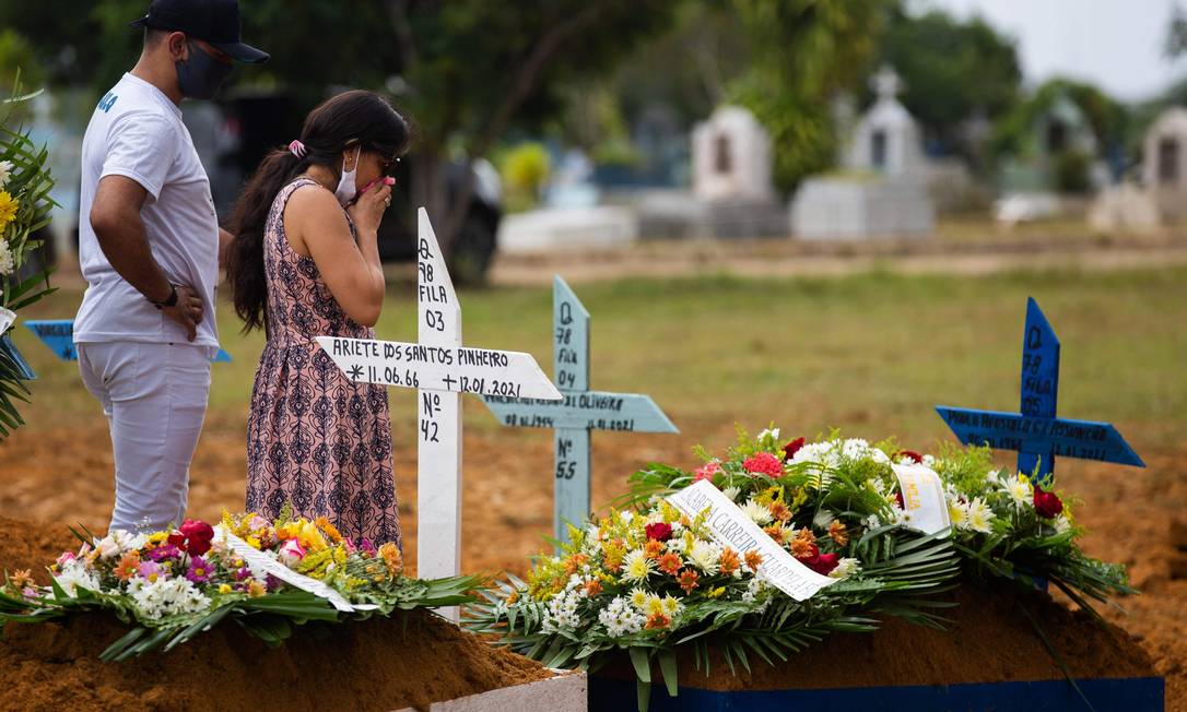 Familiares assistem ao funeral de uma vítima do Covid-19 no cemitério Nossa Senhora Aparecida em Manaus Foto: MICHAEL DANTAS/AFP