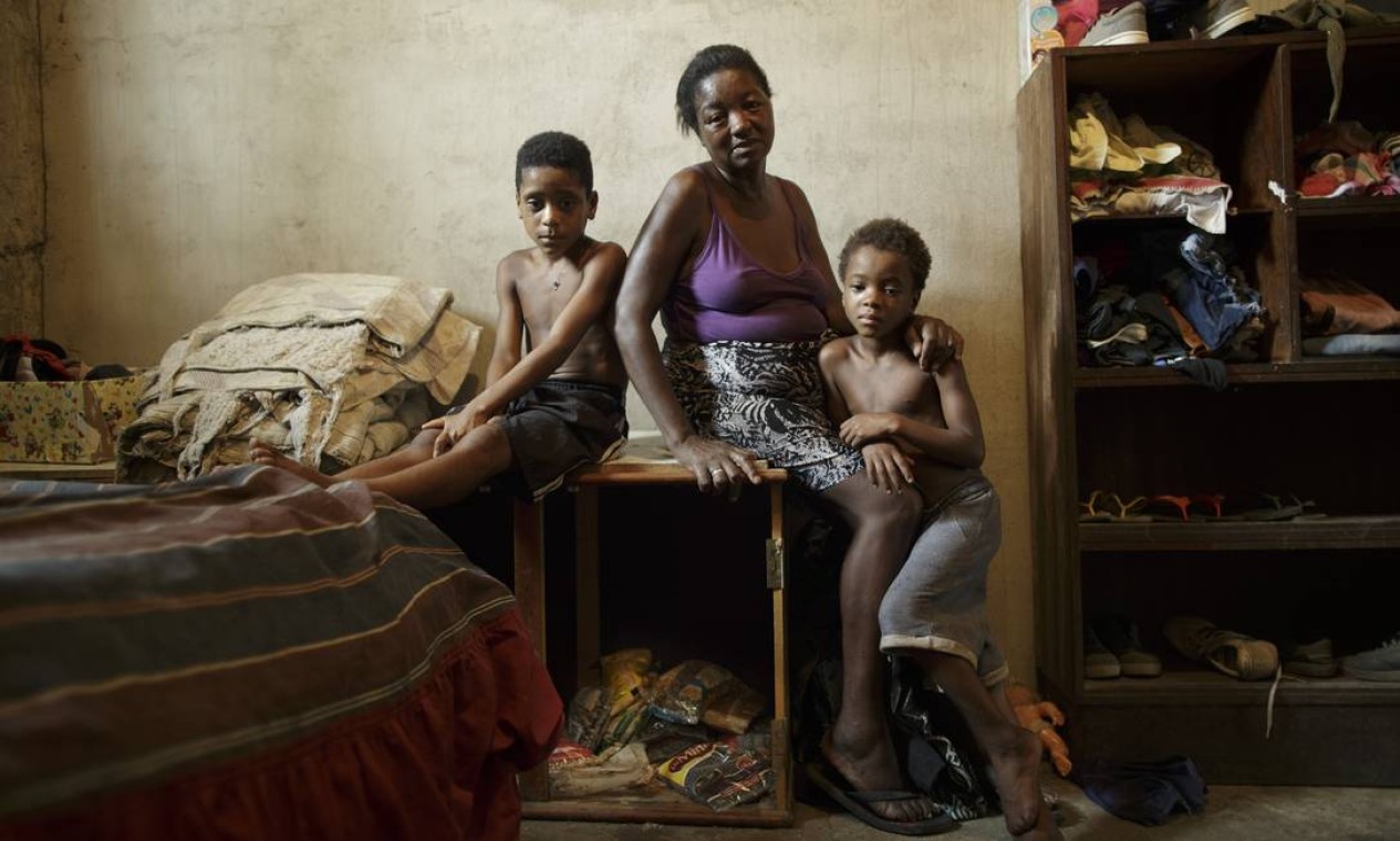 No caixote onde Simone está sentada, estão guardados os poucos mantimentos que se tem para a família, um pouco de farinha e feijão Foto: Márcia Foletto / Agência O Globo