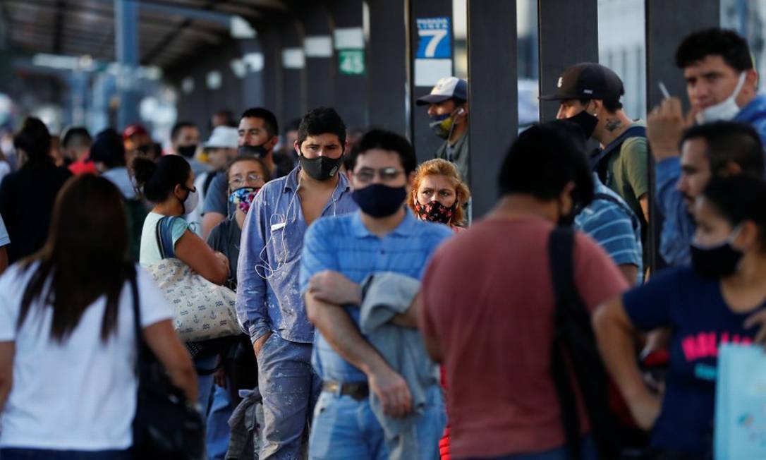 De máscara, argentinos esperam em ponto de ônibus em Buenos Aires Foto: AGUSTIN MARCARIAN / REUTERS/31-3-21